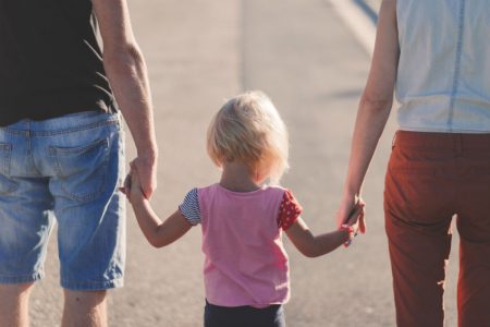 parents and child walking on beach