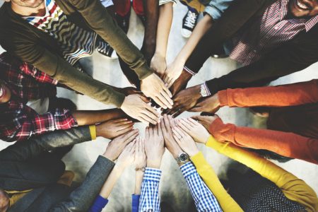 Group of people putting hands together in a circle